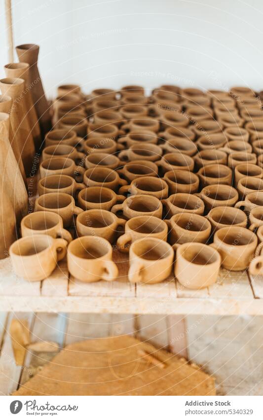 Unfertige Tonbecher auf Holztisch Vase Tasse Werkstatt handgefertigt unfertig kreativ Basteln professionell Töpferwaren Handwerk Tisch Keramik Sammlung Kunst