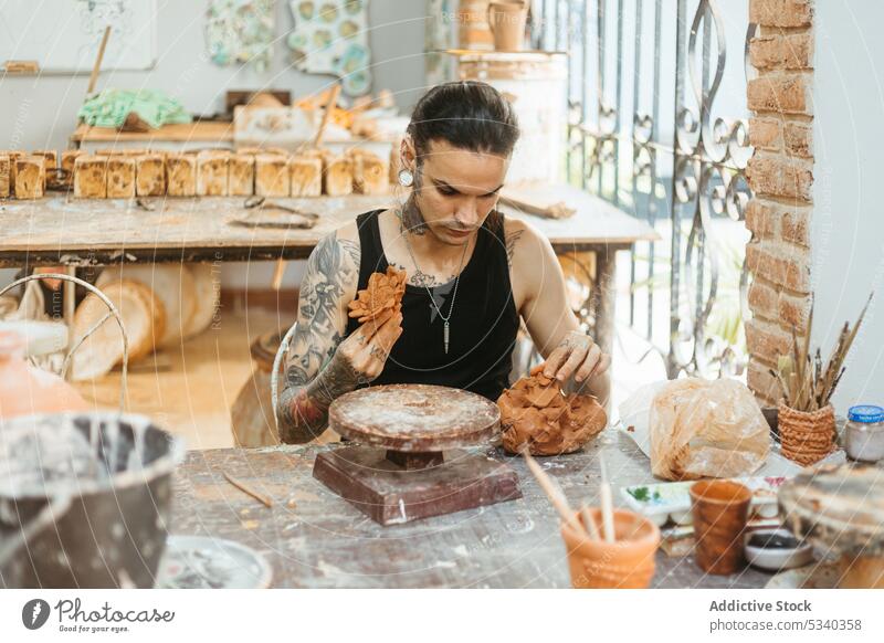 Konzentrierter Mann, der in einer Werkstatt eine Tonschale auf der Drehscheibe herstellt Töpferwaren Arbeit Konzentration Form Handwerk Rad Fähigkeit