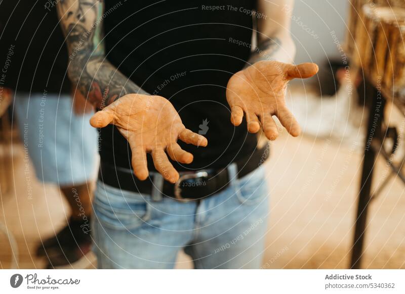 Tätowierter Mann mit schmutzigen Händen in der Werkstatt zeigen manifestieren dreckig Arbeit professionell Arbeiter Kunsthandwerker Kunstgewerbler männlich