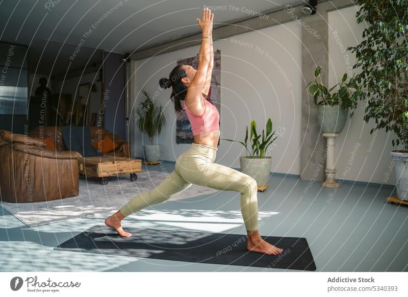 Schlanke Frau in Crescent Lunge Pose auf der Matte Yoga Asana halbmondförmiger Ausfallschritt Achtsamkeit Dehnung üben Gleichgewicht Sportkleidung Gesundheit