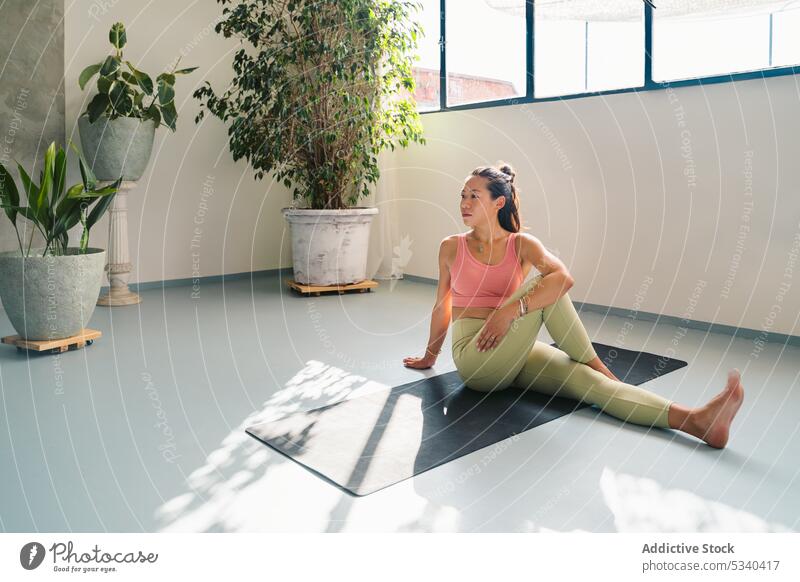 Entspannte Frau in der Sage Marichi III-Pose auf der Matte Yoga Asana sage marichis iii Gleichgewicht Windstille meditieren üben Achtsamkeit Zen Harmonie