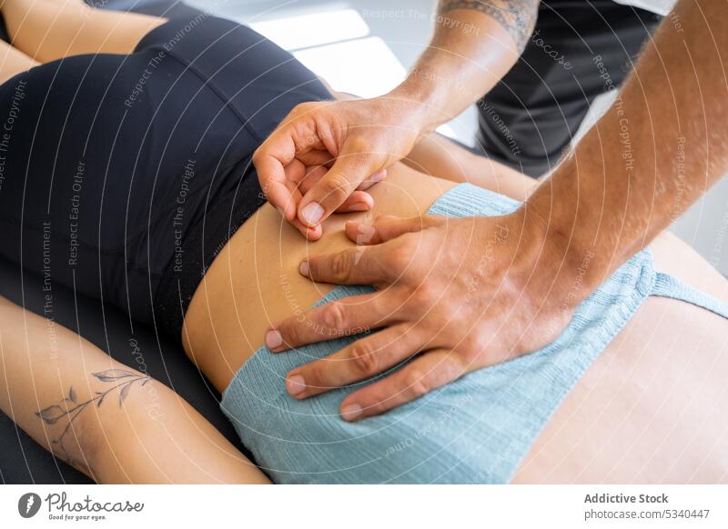 Ein männlicher Therapeut führt eine feine Nadel in den Rücken einer Kundin ein Mann geduldig Therapie Frau Akupunktur Pflege Wellness Massage Leckerbissen