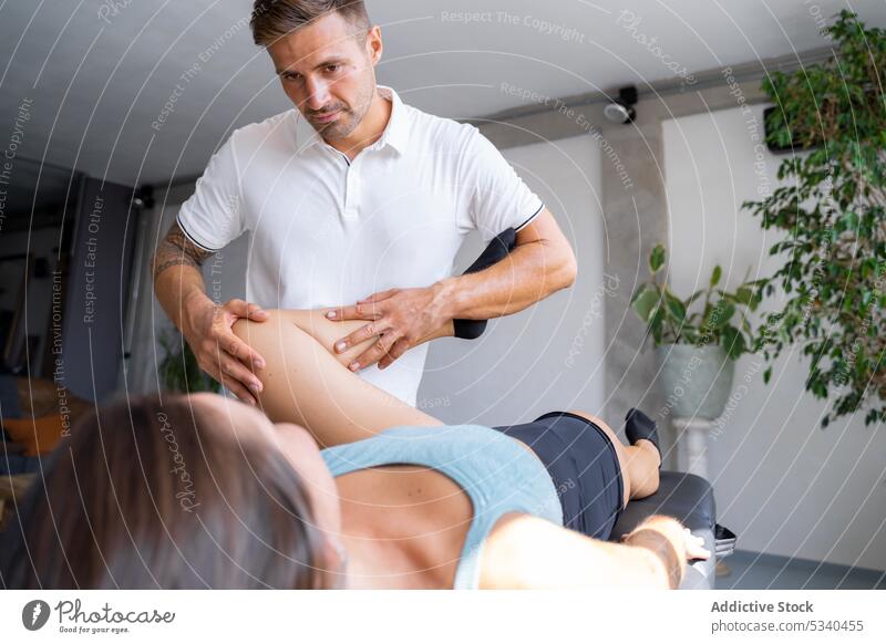 Masseur massiert das Bein einer Kundin Massage geduldig Therapeut Verfahren Rehabilitation Leckerbissen Wellness Frau Physiotherapeutin Spezialist