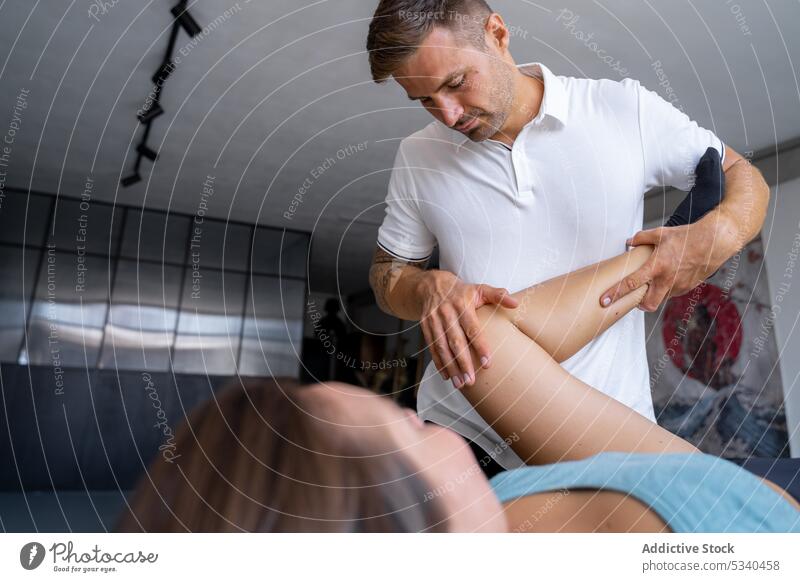 Masseur massiert das Bein einer Kundin Massage geduldig Therapeut Verfahren Rehabilitation Leckerbissen Wellness Frau Physiotherapeutin Spezialist