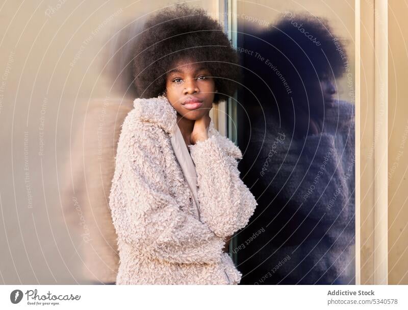 Afroamerikanischer Teenager in trendigem, gemütlichem Outfit Afro-Look heiter Metallwand Glaswand Reflexion & Spiegelung reflektieren Afroamerikaner schwarz