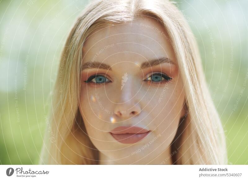 Junge blonde Frau im Freien mit Sonnenlichtflecken im Gesicht jung junger Erwachsener Jugendzeit Licht Sonnenschein sonnig glänzend in die Kamera schauen