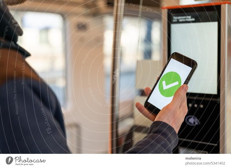 Person kauft Zugfahrkarte mit Smartphone kaufen Fahrkarte elektronisch Bildschirm grün prüfen Mark öffentliche Verkehrsmittel Straßenbahn Hand Beteiligung