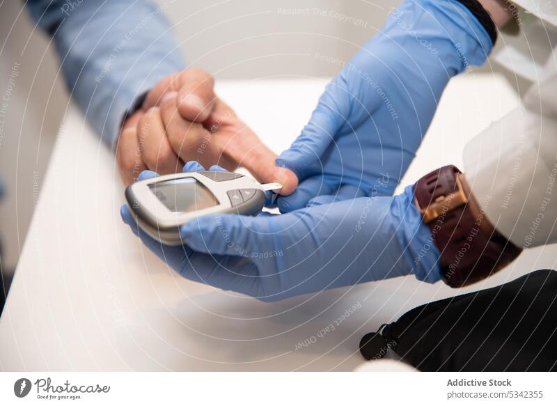 Kropfarzt untersucht Blutzucker des Patienten Arzt messen geduldig Klinik Mann Medizin Blutzuckermessgerät Prüfung Diabetes Diagnostik Zucker Glukose Person
