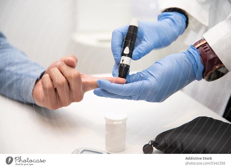 Crop-Arzt, der einem Patienten Blut abnimmt, um Diabetes festzustellen Prüfung Gerät Kontrolle Prozess Arbeiter medizinisch Diagnostik Diabetiker Mann Niveau