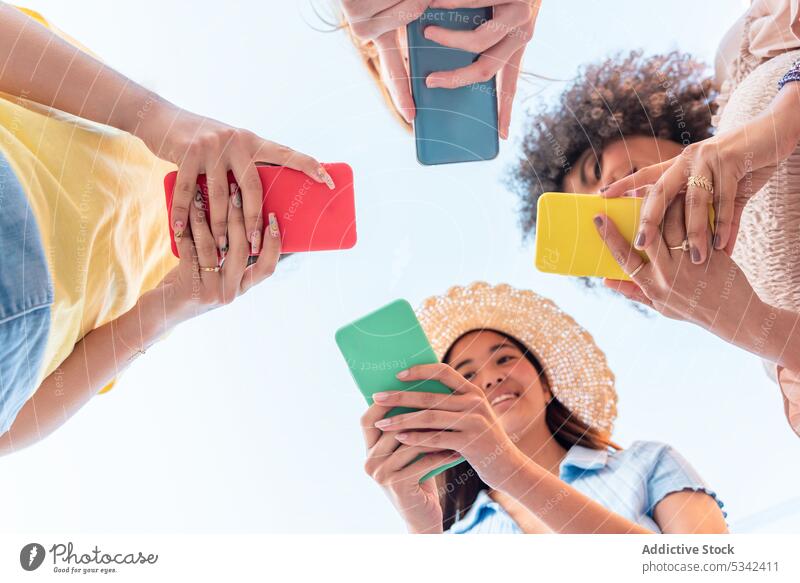 Gruppe von verschiedenen Freundinnen mit Smartphones Frauen benutzend Freundschaft kreisen Internet Nachricht online Anschluss Zusammensein Browsen