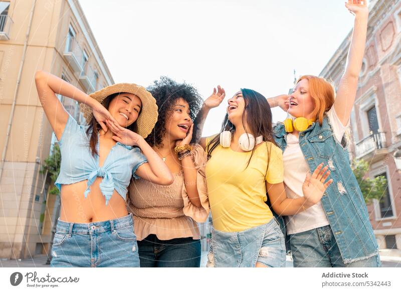 Glückliche Freundinnen auf der Straße Frauen Zusammensein schlendern Spaziergang genießen heiter Freundschaft Großstadt Freizeit multiethnisch