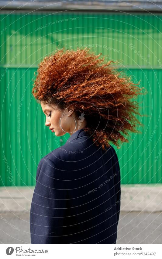 Stilvolle Frau mit roten Haaren steht auf der Straße Persönlichkeit Model emotionslos sanft Blick selbstbewusst Vorschein filigran jung krause Haare Frisur