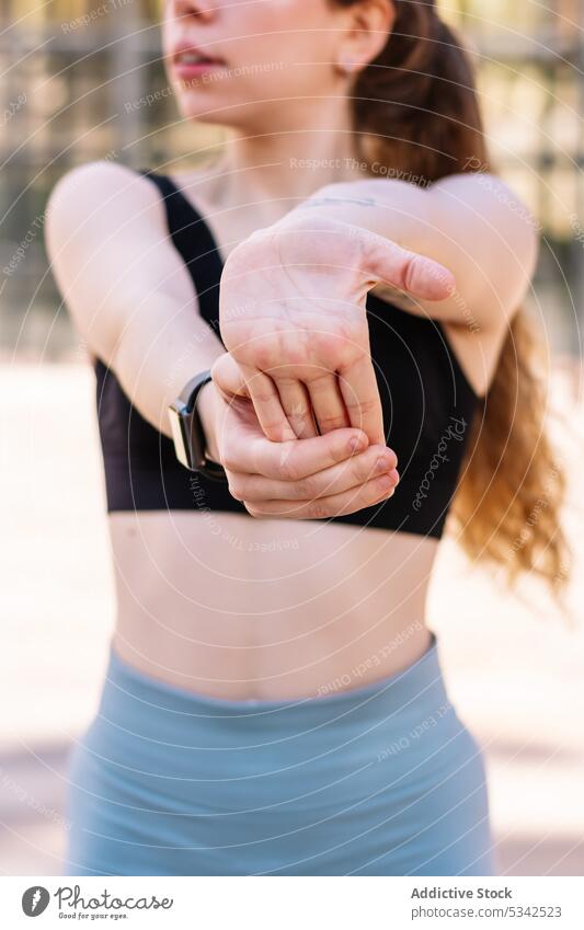 Crop-Sportlerin streckt die Arme auf der Straße Fitness Übung Dehnung Athlet Training Wohlbefinden Wellness Handgelenk Aktivität Gesundheit passen