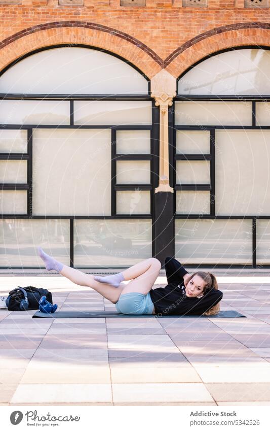 Frau übt auf einer Matte auf der Straße Übung üben Training beweglich physisch Fahrradstellung Wellness Yoga Gleichgewicht Aktivität Wohlbefinden Gesundheit