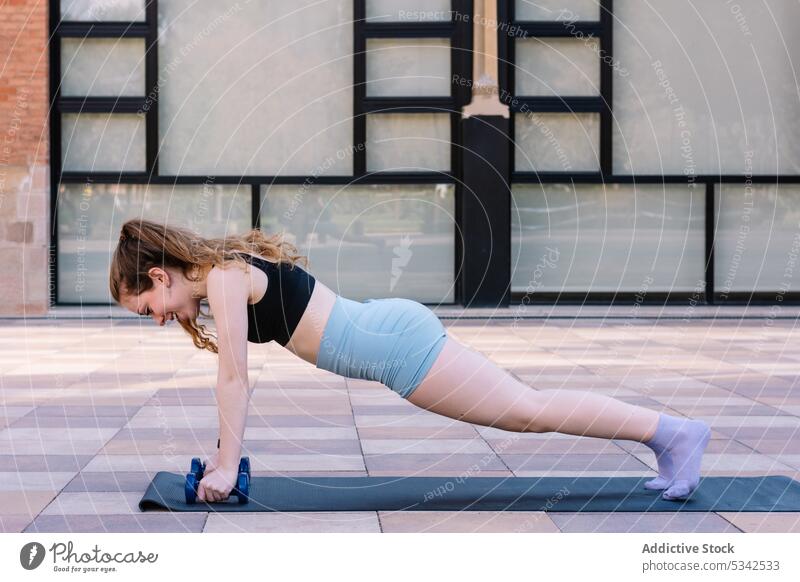 Konzentrierte Frau bei einer Plank-Übung Yoga phalakasana Training Schiffsplanken üben Wellness Konzentration Straße Asana Wohlbefinden jung beweglich Dame