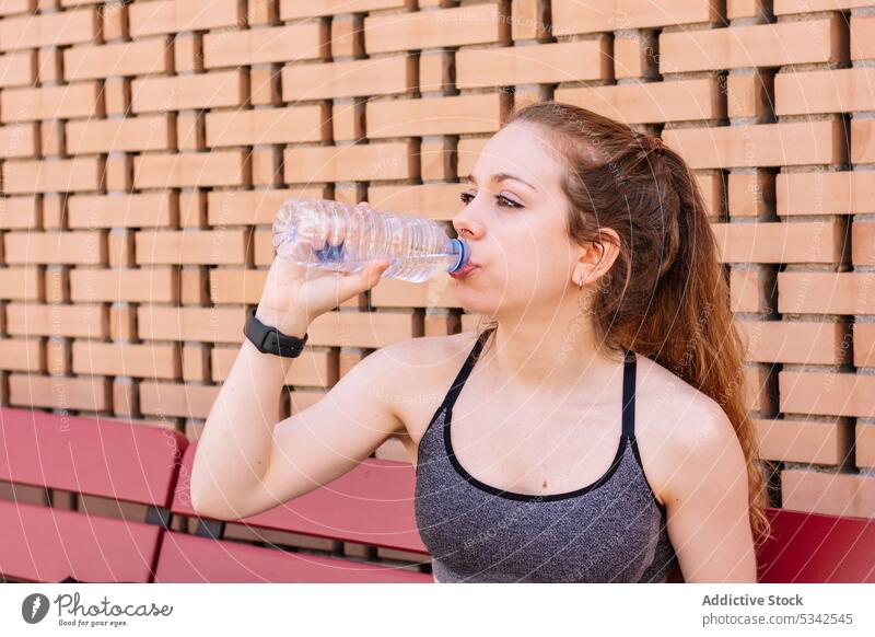 Sportlerin trinkt nach dem Training Wasser aus einer Flasche trinken Pause Hydrat ruhen Athlet Durst Fitness passen Wellness Wohlbefinden Gesundheit Frau müde