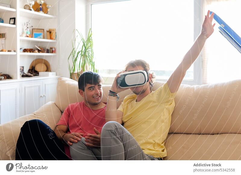 Schwules Paar benutzt VR-Brille zu Hause zuschauen Sofa Männer schwul Schutzbrille Homosexualität lgbt Transgender Spieler ruhen Zusammensein Video Headset