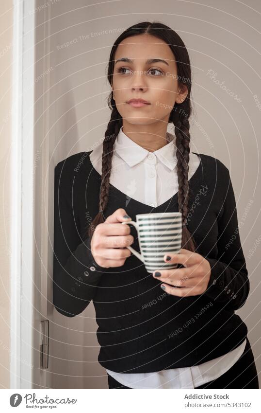 Porträt einer atemberaubenden, stilvoll konzentrierten jungen Frau Kaffee Tür Stil Tasse selbstbewusst nachdenklich Heißgetränk besinnlich gotisch hispanisch