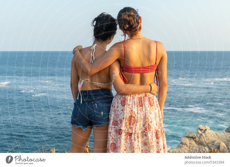 Unbekannte Frauen umarmen sich im wogenden Meer Umarmung Freund MEER Sonnenuntergang Sommer Urlaub Küste Zusammensein winken Ufer Badebekleidung