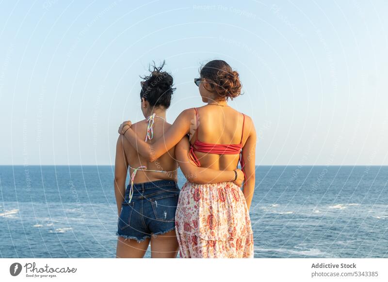 Unbekannte Frauen umarmen sich im wogenden Meer Umarmung Freund MEER Sonnenuntergang Sommer Urlaub Küste Zusammensein winken Ufer Badebekleidung
