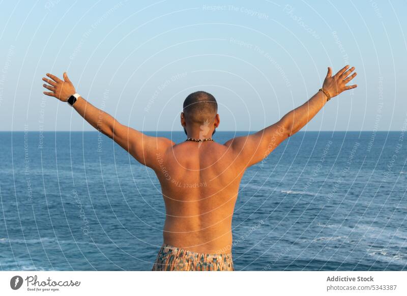 Anonymer ruhiger Mann mit erhobenen Armen gegen das endlose Meer MEER genießen sich[Akk] entspannen Ausflug Urlaub Freiheit sorgenfrei Strand Sommer Natur