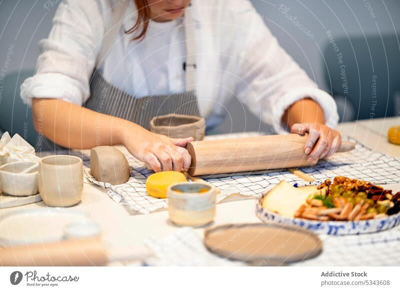 Anonyme Frau, die während eines Töpferkurses einen Rollstift benutzt Handwerkerin Töpferwaren Ton Nudelholz Platte handgefertigt rollen Kunstgewerbler Rolle