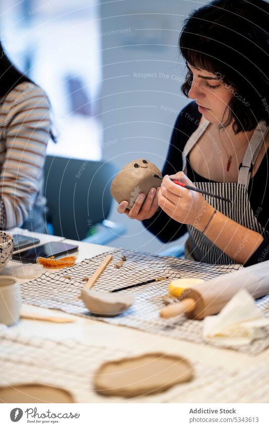 Weibliche Kunsthandwerkerin zeichnet auf Ton Frau Kunstgewerbler Farbe kreieren Handwerk diy handgefertigt Werkstatt Töpferwaren kreativ Basteln Hobby Fähigkeit