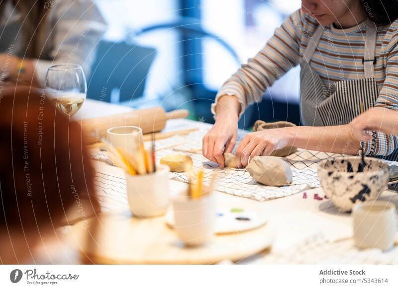 Crop-Frauen, die während des Unterrichts gemeinsam Tontassen herstellen kreieren Zusammensein Werkstatt Töpferwaren Tisch handgefertigt Basteln Handwerk kreativ