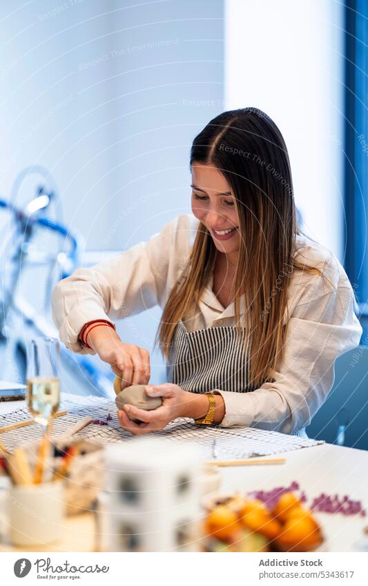 Lächelnde Frau beim Formen einer Tonschale in einer Werkstatt Töpferwaren machen Kunstgewerbler handgefertigt Handwerk Keramik Hobby Schalen & Schüsseln