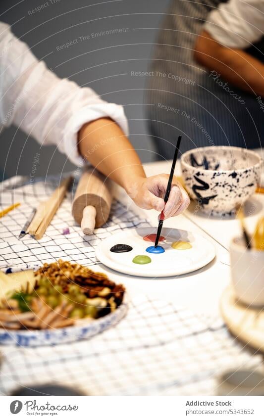 Unbekannte Person malt mit Palette in der Werkstatt Farbe Künstler Pinselblume Meisterklasse zeichnen farbenfroh kreativ Tisch Handwerk Atelier Hobby Kunst