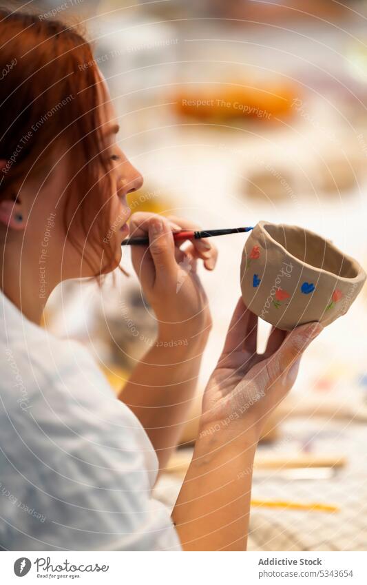 Crop-Frau dekoriert Tontasse mit Farbe Tasse Töpferwaren machen Keramik Kunstgewerbler Künstler handgefertigt Handwerk Atelier Handwerkerin Werkstatt