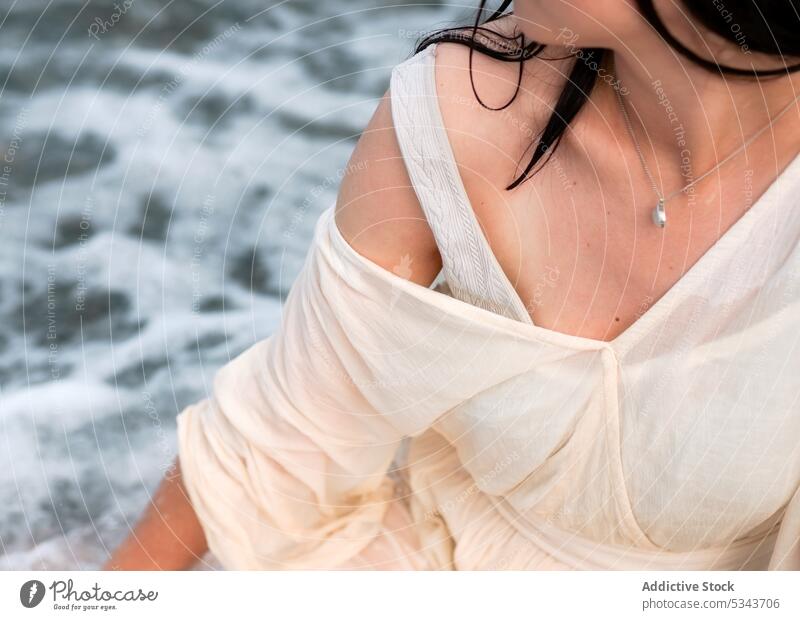 Crop Frau in weißem Kleid in der Nähe von Meer ruhen MEER Strand Resort Sommer Urlaub sich[Akk] entspannen Feiertag Küste winken Wasser Ufer genießen reisen