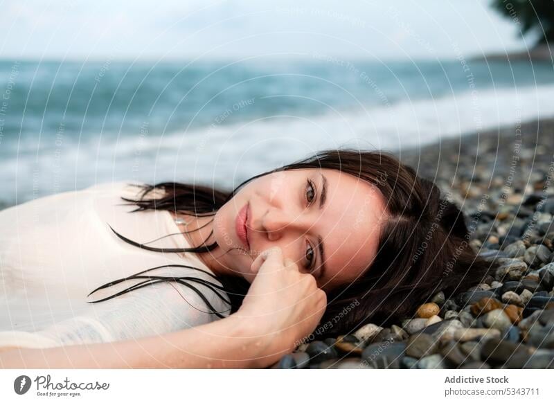 Charmante Frau am steinigen Meeresufer liegend MEER Sommer Ufer ruhen Urlaub Lächeln Lügen Küste winken Glück Strand positiv sich[Akk] entspannen Stein Wasser