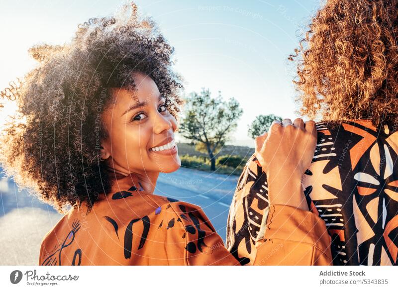 Glückliche schwarze Frau mit Hand auf anonymer Freundin Lächeln Straße positiv Park Sommer sorgenfrei heiter froh Vorschein Stil Afroamerikaner ethnisch