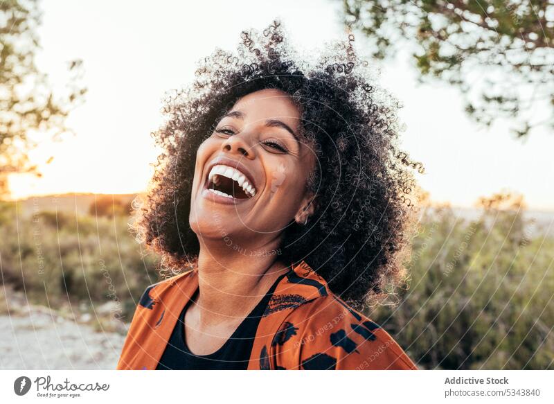 Fröhliche schwarze Frau lachend auf dem Lande Lachen heiter positiv Porträt Glück Optimist krause Haare expressiv Spaß Afroamerikaner ethnisch Lächeln Freude