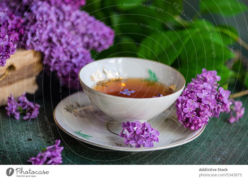 Vorderansicht eines leckeren schwarzen Tees in einer alten Tasse auf einem mintgrünen Betontisch aromatisch Getränk Schwarzer Tee Blütezeit Blumenstrauß Kasten