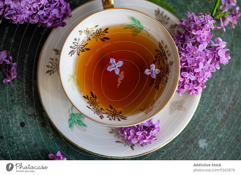 Draufsicht auf einen leckeren schwarzen Tee in einer alten Tasse auf einem mintgrünen Betontisch aromatisch Getränk Schwarzer Tee Blütezeit Blumenstrauß Kasten