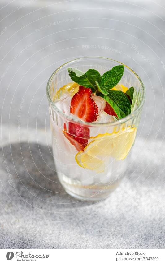 Sommercocktail mit Eis, Minze und Erdbeere vor unscharfem Hintergrund Getränk Cocktail trinken frisch Glas Blätter Zitrone organisch roh reif Saison