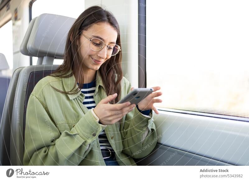 Junge Frau benutzt Smartphone im Bus benutzend Passagier Verkehr Lächeln reisen Browsen Surfen Fenster jung Gerät Ausflug lässig Mobile Telefon Arbeitsweg