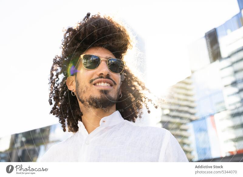 Ethnischer lächelnder Mann mit Brille auf der Straße Browsen trendy Großstadt Sonnenbrille benutzend Gerät ethnisch männlich schwarz Afroamerikaner Stil