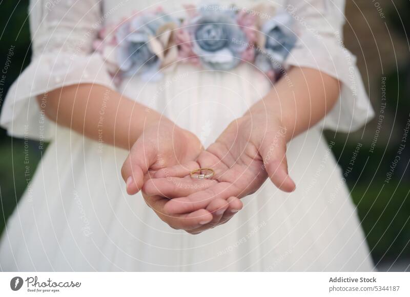 Unbekanntes Mädchen mit Ehering in den Händen Hochzeit Festakt Träger Ring zeigen Braut Veranstaltung Heirat manifestieren Kind feiern geblümt elegant Anlass