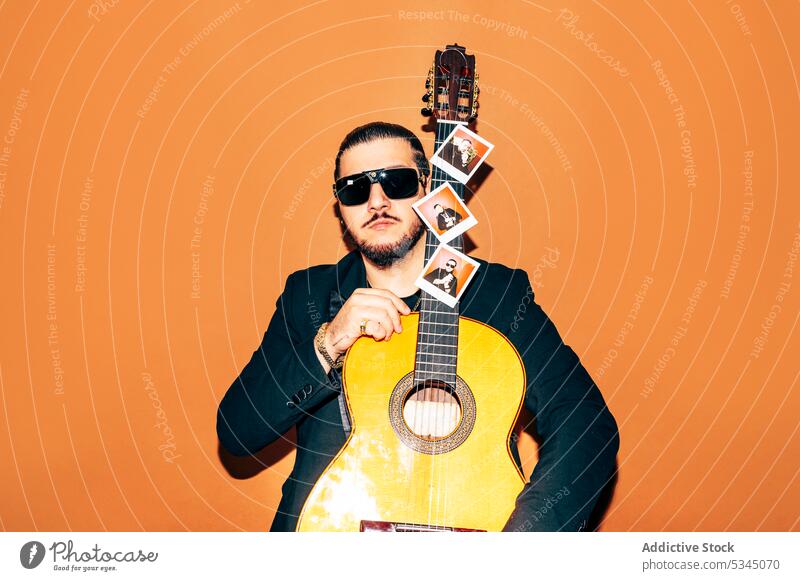Gefühlsloser Mann mit Akustikgitarre im Studio Gitarre Hipster akustisch Stil Musiker Gitarrenspieler trendy Sonnenbrille männlich Vollbart Individualität
