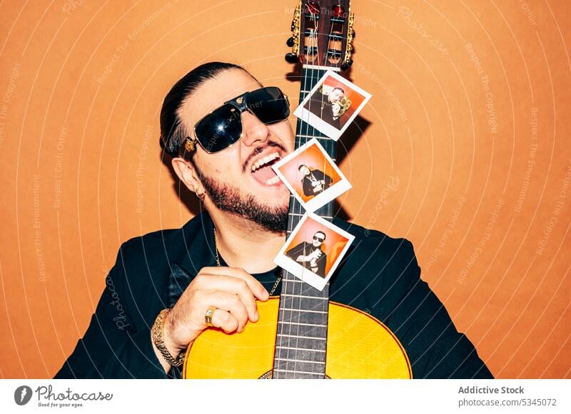 Mann mit Akustikgitarre im Studio Gitarre Hipster akustisch Stil Musiker Gitarrenspieler trendy Sonnenbrille männlich Vollbart Individualität selbstbewusst