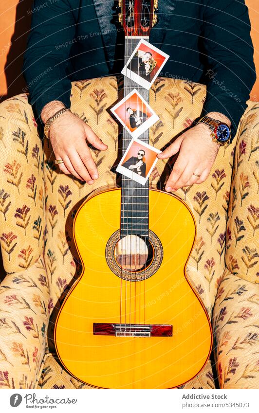Unbekannter Mann neben Akustikgitarre auf Sessel Gitarre Atelier Gitarrenspieler Musiker akustisch Foto Talent Schnur Hobby männlich Instrument Melodie Klang
