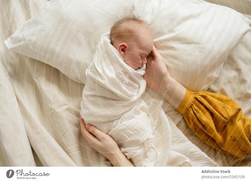 Unbekannte Frau tröstet neugeborenes Baby im Bett Kind schlafen wickeln Kraulen berühren Liebe Säugling Komfort gemütlich Mutter friedlich sich[Akk] entspannen