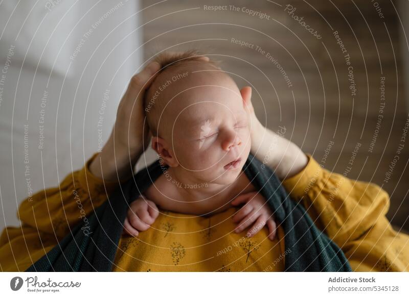 Crop-Mutter hält schlafendes Baby in der Trage Frau sich[Akk] entspannen Wickelträger Portage Liebe Angebot Schlafzimmer Pflege bezaubernd neugeboren heimwärts