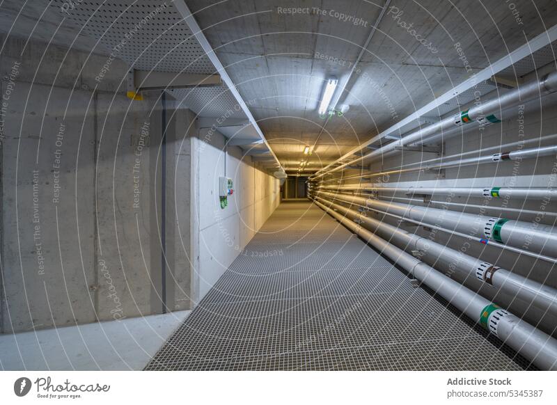 Leerer unterirdischer Tunnel mit Sanitärrohren Stollen Gang Röhren Wasser Gas Pipeline Klempnerarbeit Abfluss System Maschinenbau Saal Keller Lagerhalle