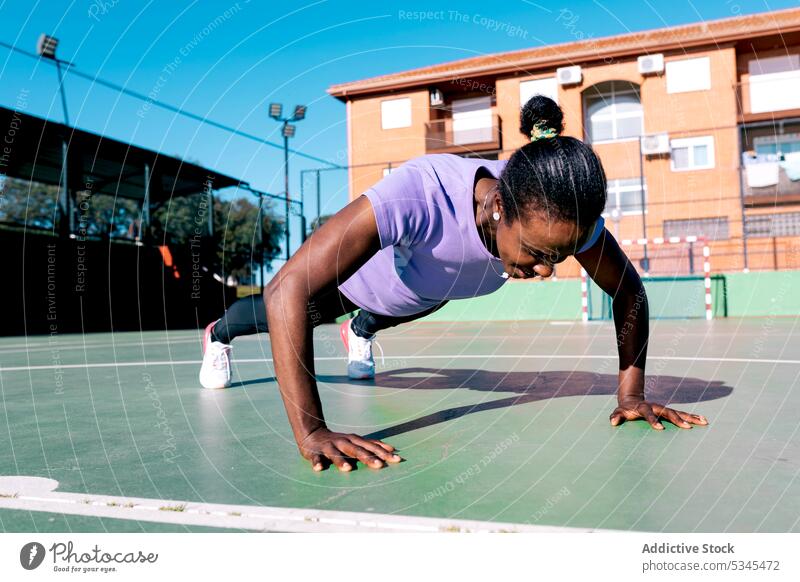 Starke schwarze Sportlerin macht Liegestütze beim Training im Freien hochschieben Übung Sportpark Bestimmen Sie Ausdauer Fitness Frau Gesunder Lebensstil