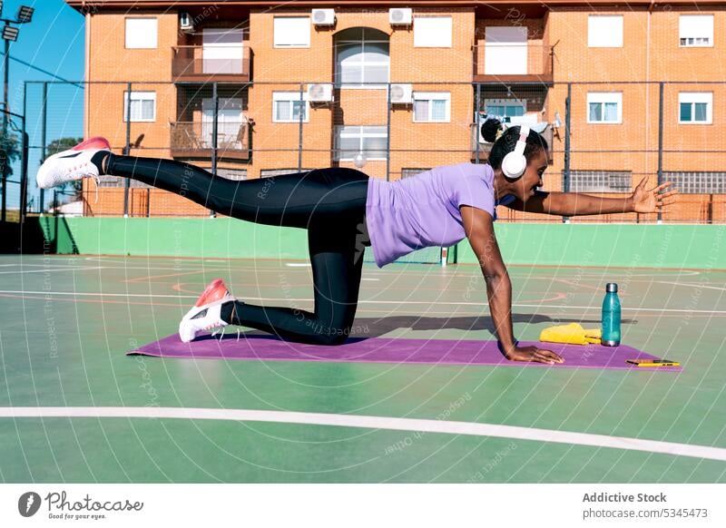 Fitte afroamerikanische Sportlerin, die beim Training im Park Musik hört Übung Fitness Gesundheit Wellness zuhören Frau stark Sportpark Erwachsener