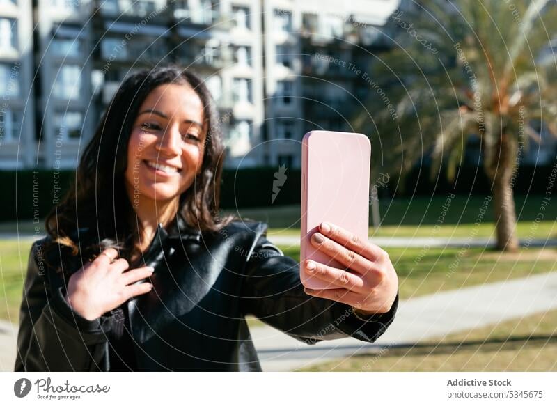 Glückliche ethnische Frau macht ein Selfie Smartphone benutzend Straße urban Textnachricht online Internet Anschluss jung Apparatur Gerät Funktelefon Surfen
